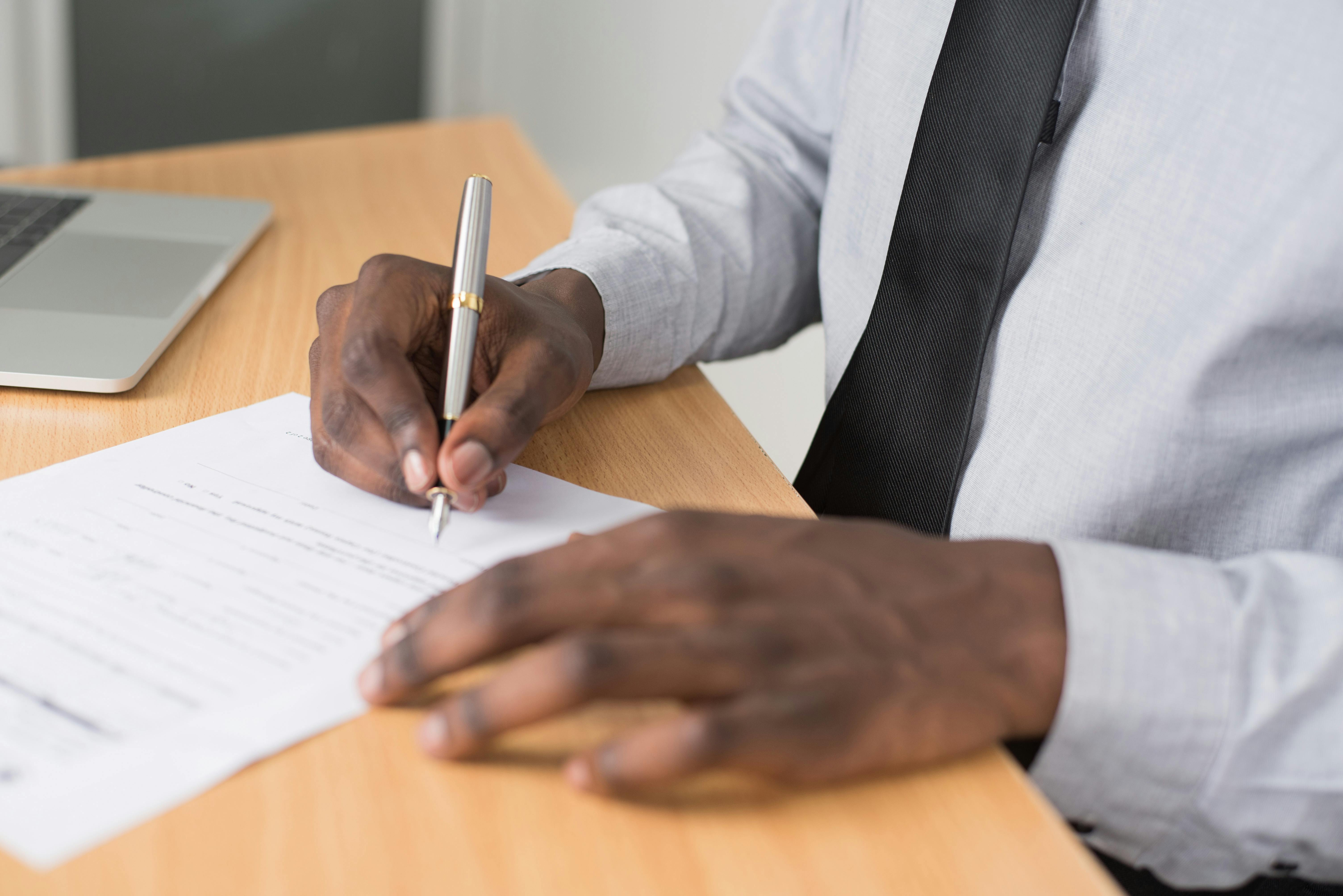 Close up of a person signing their lease agreement